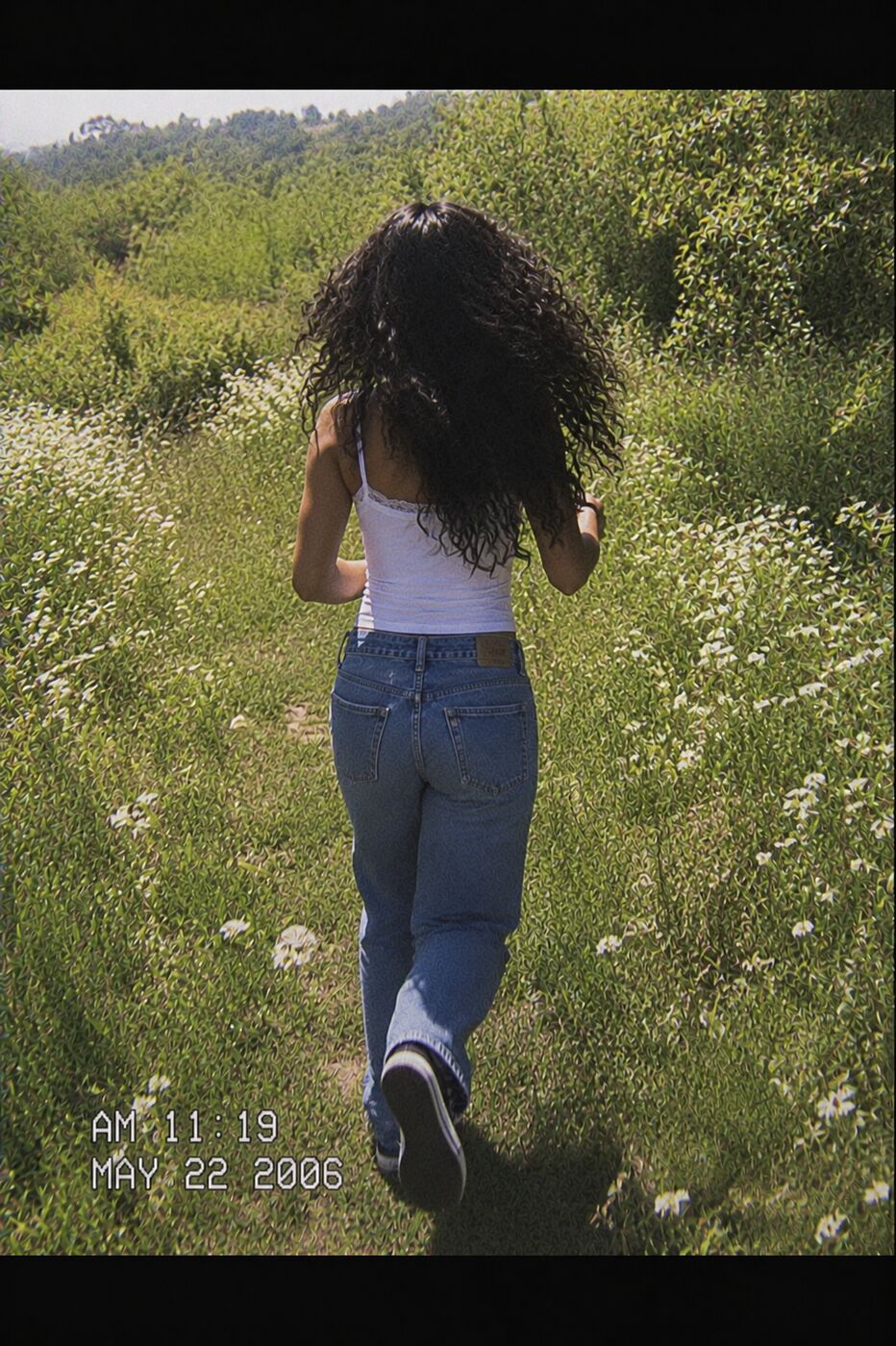 Deva walking away through a wildflower field, vintage film style